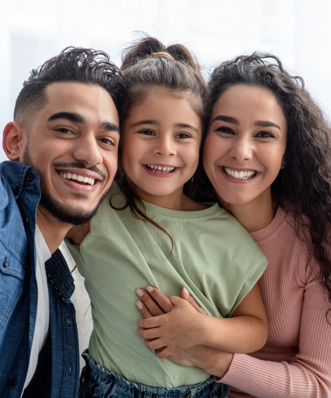 Happy family of three smiling together against white background for dental practice.
